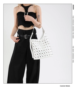 Gros plan détaillé d'un sac hobo blanc de style punk avec des ornements de clous argentés