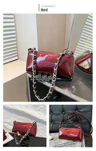 Close-up of red patent leather baguette bag with silver chain and metal triangle logo