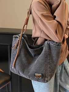 Black washed denim tote bag with brown woven rope strap and minimalist hobo design