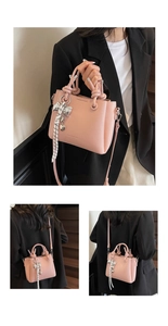 Detail view of pink lychee pattern bucket bag with bow ribbon and heart charm