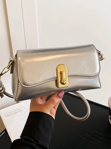 Silver glossy leather crossbody bag for women with a prominent golden U-shaped clasp