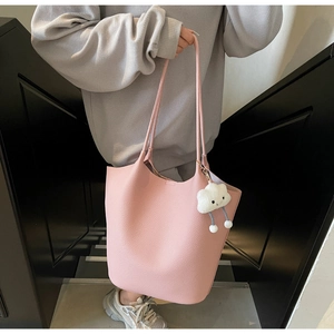 Detailed texture of pink litchi grain leather bucket bag with cute cloud charm