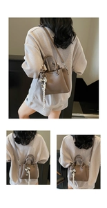 Detail showing the brown lychee texture leather bucket bag with a decorative bow charm
