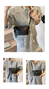 Dettaglio mini borsa a secchiello in pelle nera con trama litchi e tracolla sottile