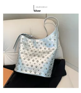 Détails d'un sac hobo argenté orné de clous punk métalliques avec fine bandoulière élégante