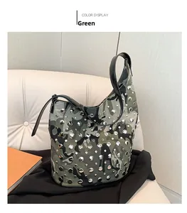 Vue détaillée du sac seau camouflage avec des rivets argentés et une bandoulière en cuir