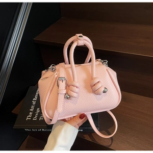 Dettaglio borsa a mano rosa in pelle con manici a nodo e fibbie in metallo argento