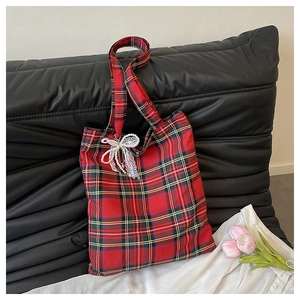 Detail of red plaid tote bag featuring a delicate white lace bow and pearl decoration