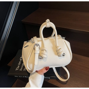 Dettaglio borsa in pelle litchi bianca con manici annodati e finiture in metallo argento