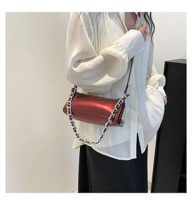 Polished burgundy patent leather baguette bag with silver chain strap shown on model