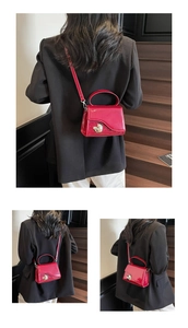 Dettaglio mini borsa in pelle verniciata rossa con fibbia a cuore argento e manico