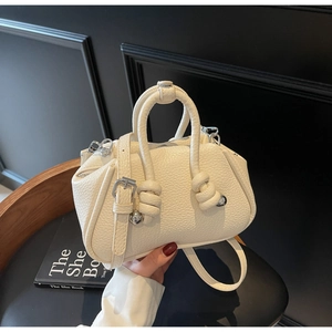 Dettaglio borsa crema in pelle martellata con nodo decorativo e fibbia a sfera in argento