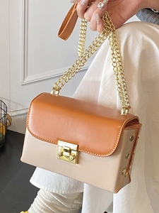 Contrast color orange and beige crossbody bag with gold chain straps and metal lock