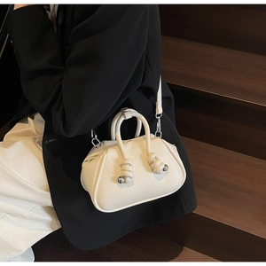 Dettaglio borsa in pelle martellata color crema con dettagli in metallo argento