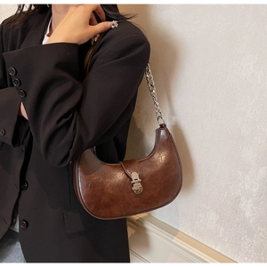 Detail of a dark brown PU leather hobo bag with a silver buckle and chain shoulder strap