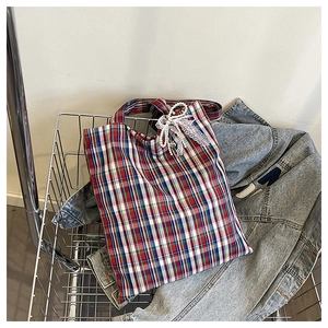 Detail of plaid tote bag with lace bow in a silver shopping basket for casual look