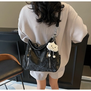 Détail du sac cabas noir à texture plissée, zip argenté et breloque nuage blanc