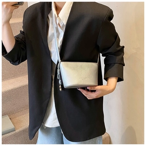 Borsa a secchiello argento con grana litchi indossata da modella in stile minimalista