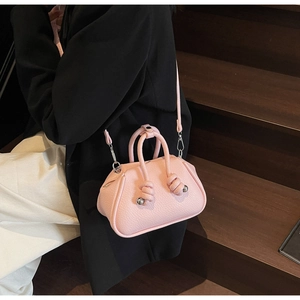 Dettaglio borsa rosa a grana di litchi con manici a doppio nodo e dettagli in metallo argento