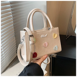 Détail du petit sac beige carré orné de cœurs colorés et du logo Chard distinctif