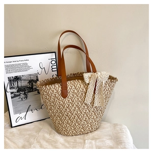 Detail of hand-woven straw tote with elegant lace bow and brown leather handles