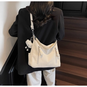 Détail du sac fourre-tout en nylon blanc crème avec poche latérale et charm nuage en peluche