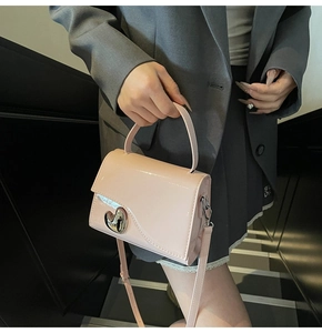 Dettaglio della borsa in pelle verniciata rosa con fibbia in metallo argentato a cuore