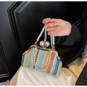 Close-up of colorful woven straw evening bag featuring a double large pearl clasp and handle