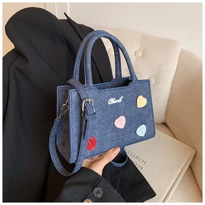 Détail du mini sac cabas en denim bleu avec patchs cœurs colorés et logo Cherd