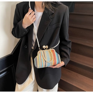Detailed view of rainbow woven shell bag with pearl chain strap and gold clasp closure