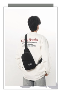 Détail du sac de poitrine noir en nylon avec écusson logo et anneau en D sur un mannequin homme