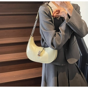 Close-up of light green hobo bag featuring silver chain strap and metal buckle closure