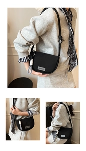 Detail view of black crescent crossbody bag with mearey logo and rope shoulder strap