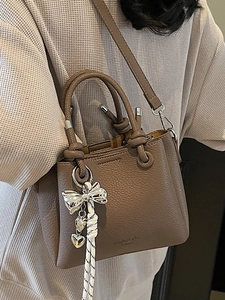 Litchi texture taupe bucket bag with silver bow charm and heart metal pendant