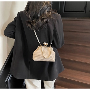 Detail of elegant straw woven bag with large pearl clasp and pearl beaded strap