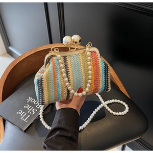 Close-up of colorful striped straw evening bag with large pearl clasp and chain