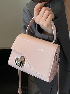 Borsa a mano in vernice rosa con decoro a cuore in metallo argentato e tracolla