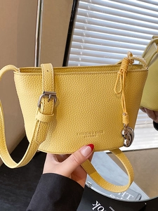 Secchiello chic in pelle gialla con trama litchi, ciondolo a cuore e tracolla regolabile