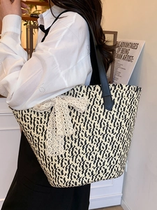 French style woven straw tote bag with cream lace bow and black leather shoulder strap