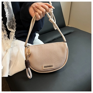 Close-up of crescent shoulder bag featuring mesh texture and knotted rope strap detail