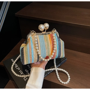 Close-up of rainbow woven straw clutch with pearl clasp and long pearl chain strap