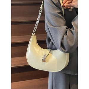 Minimalist light green half-moon hobo bag with silver chain strap shown in city style