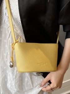 Elegante borsa a secchiello gialla in pelle motivo litchi con ciondolo e tracolla sottile