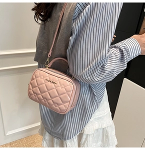 Détail du sac bandoulière matelassé rose avec logo en métal et finition brillante
