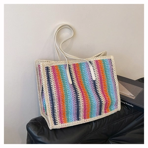Detailed close-up of a colorful woven tote bag with vibrant vertical stripes and white straps