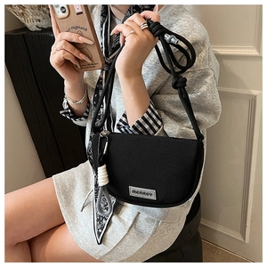 Detail of black nylon mesh crescent crossbody bag with woven rope strap and brand tag