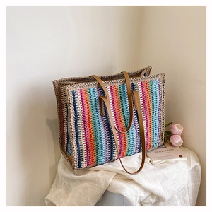 Detail of colorful woven tote bag featuring vibrant stripes and brown leather handles