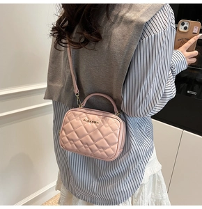 Détail d'un petit sac carré rose avec motif losanges et finitions métalliques dorées