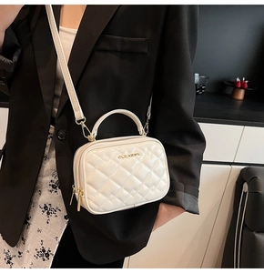 Détail du sac bandoulière matelassé blanc en cuir verni brillant avec finitions dorées