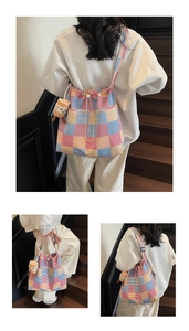 Detail of colorful plaid canvas tote bag with drawstring closure and plush pendant